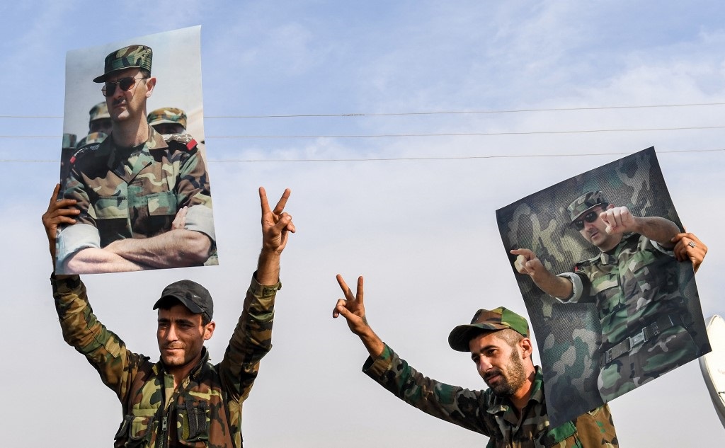 جنود الحكومة السورية يحملون صورة بشار الأسد على حدود مدينة منبج