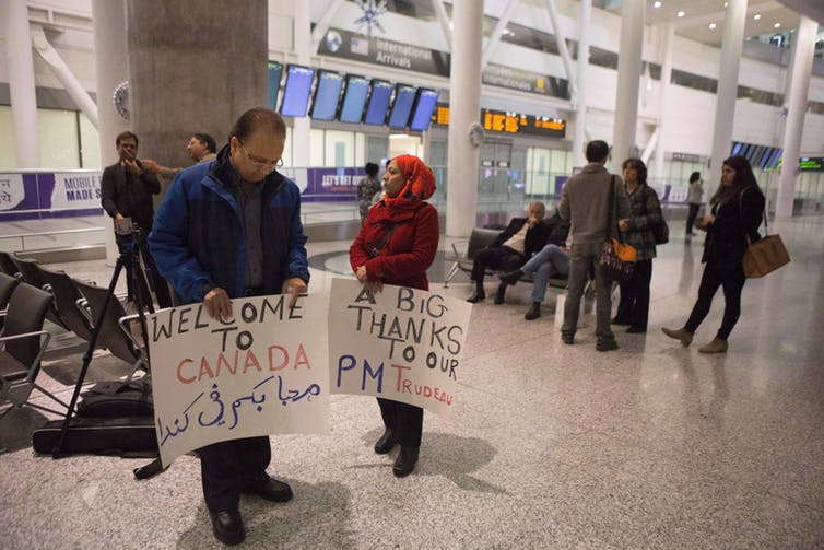 المهنئون بانتظار وصول أول طائرة حكومية تحمل اللاجئين في مطار تورنتو