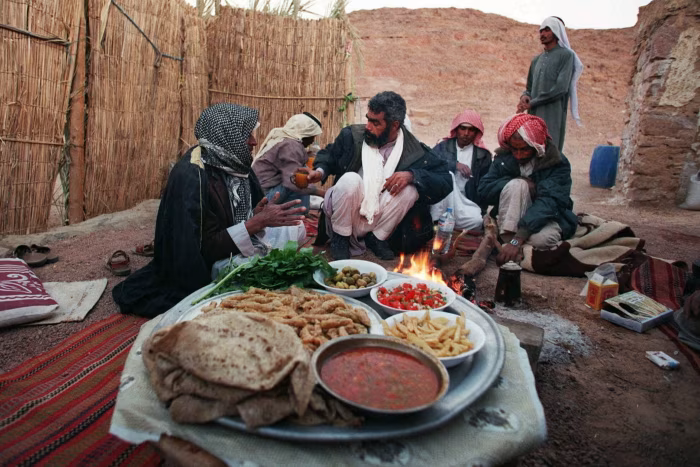 أفراد من قبيلة الترابين البدوية يستعدون لتناول وجبة الإفطار خلال شهر رمضان.